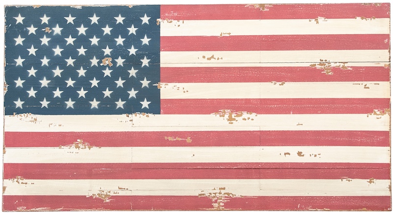 A decorative painted-wood American flag showing age with minor wear and chips to create a vintage look.